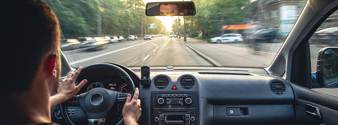 The view from inside a car, looking over the driver’s shoulder at the dashboard and through the windscreen to the road ahead. Ooono new market launch